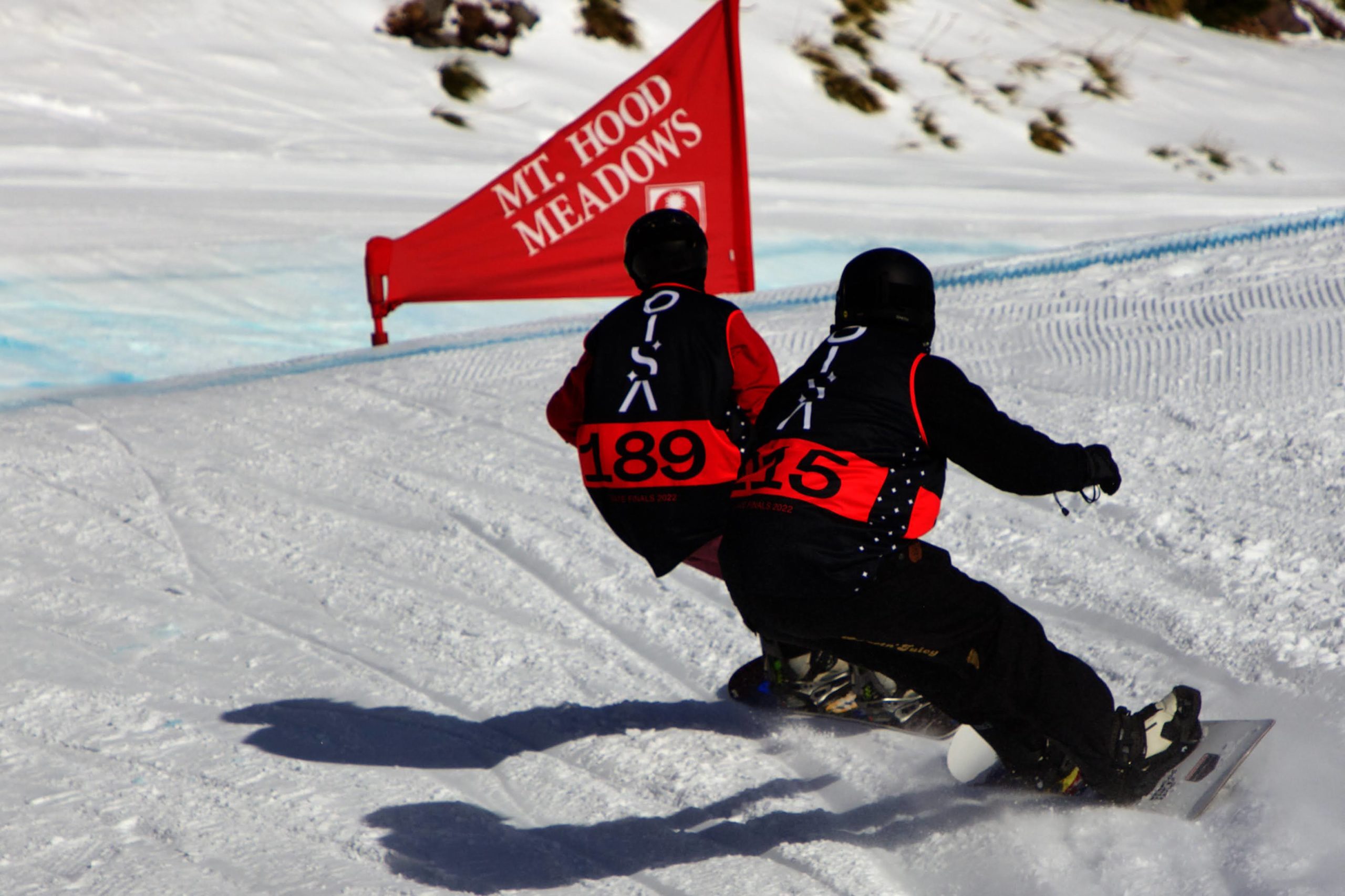 2 snowboarders race to a corner in a boardercross race at Mt Hood Meadows